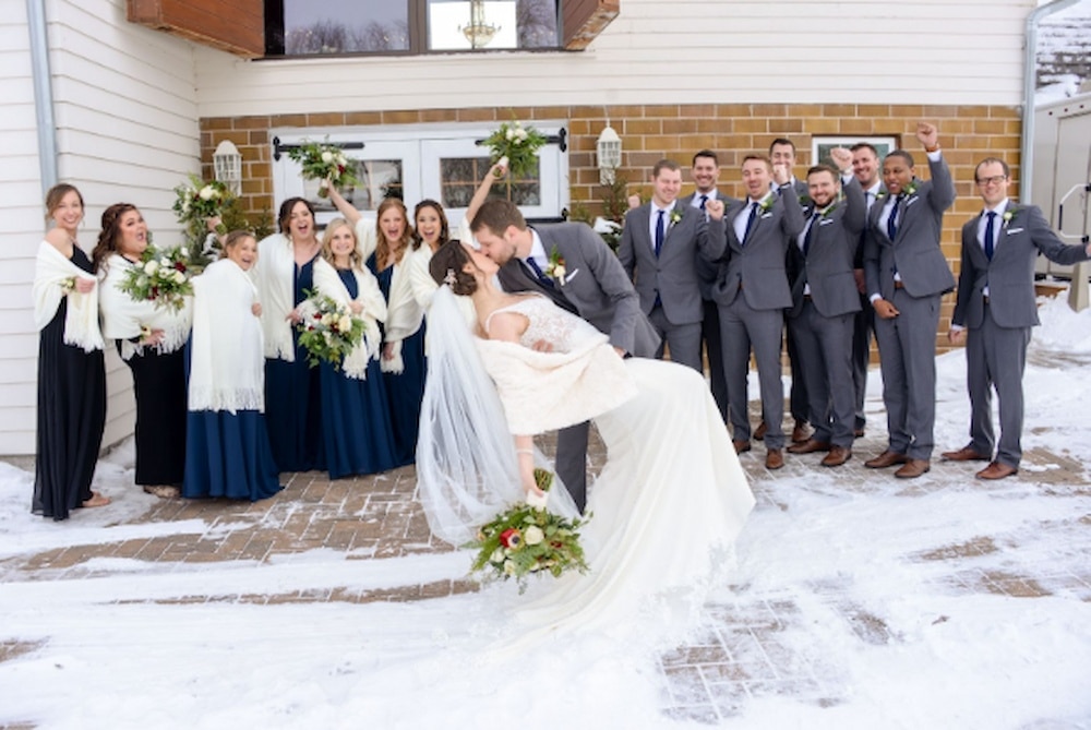 Groom holding & kissing the bride outside Green Acres Event Center